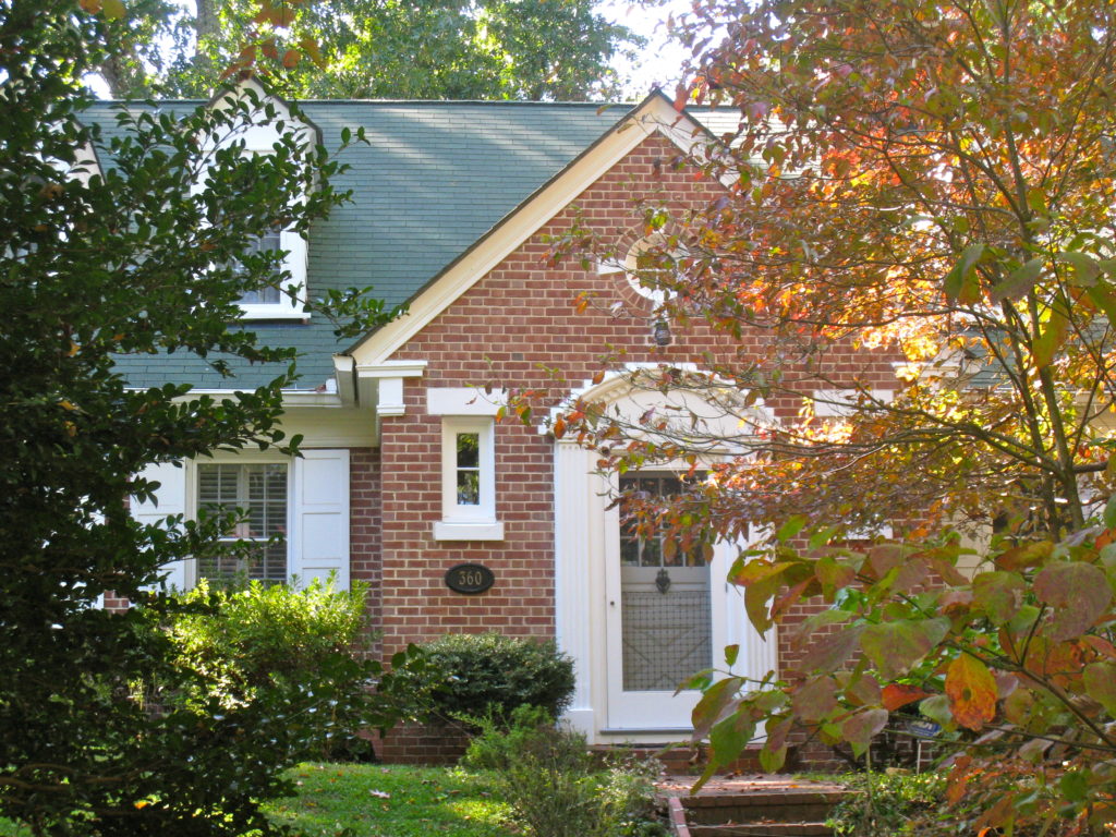 Brick home with white trim and fall foliage