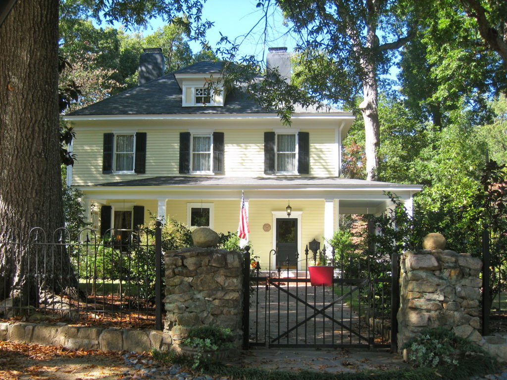 Yellow home with black storm shutters
